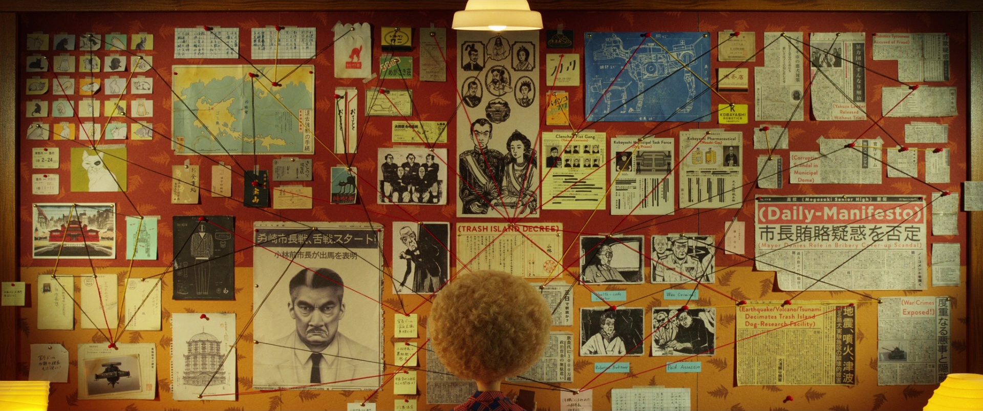 A red corkboard covered in photos, maps and clippings linked by string, with a curly-haired figure seen from behind at the bottom